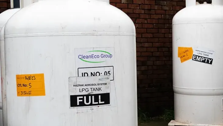 Two white metal LPG tanks - one larger and full, one smaller and empty.